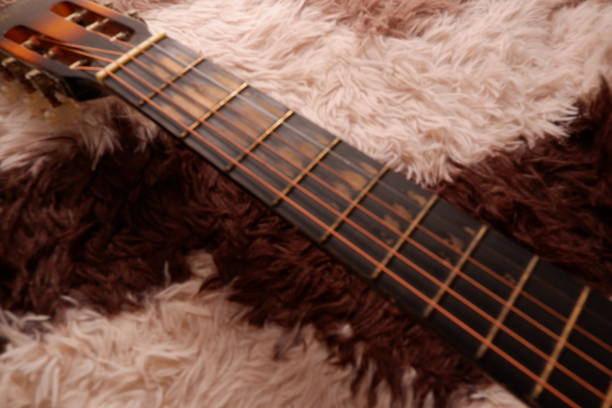istock Used guitar with broken metal string on a carpet 1358586390