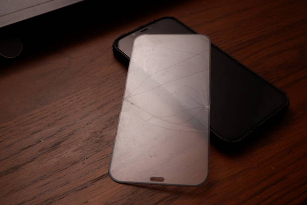 istock Broken smart phone screen protector film on wooden table 1358586417