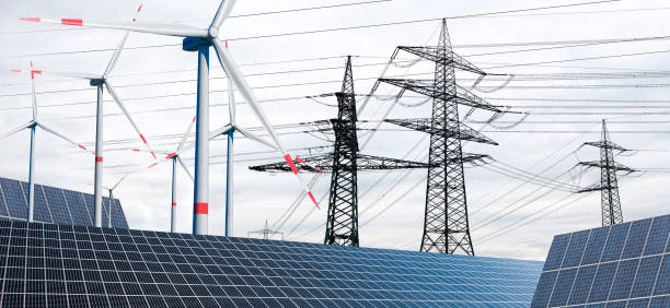 istock Power poles with wind turbines and solar panels 1358586641