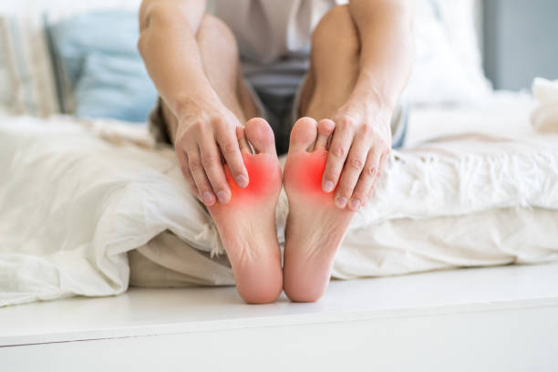 Foot pain, man suffering from feet ache at home stock photo