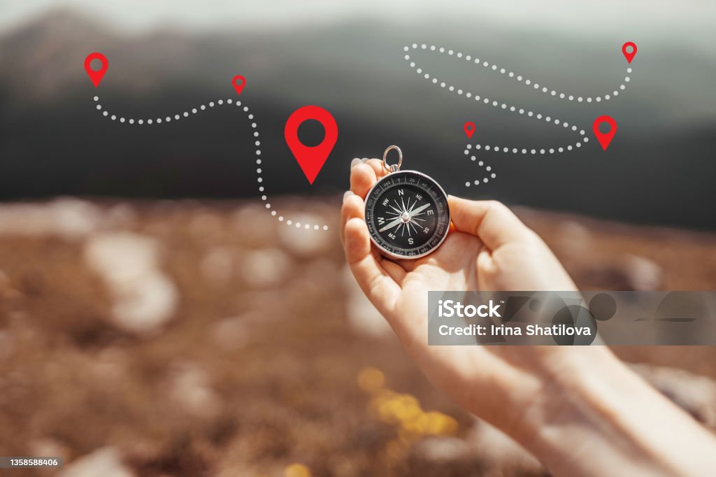 Traveler hand holds a compass on the beautiful Carpathian mountains view in a sun. Horizontal banner with place for text. Vacation and travel Traveler hand holds a compass on the beautiful Carpathian mountains during vacation. Horizontal banner with place for text. Technology interenet and travel adventure concept. Navigational Compass Stock Photo
