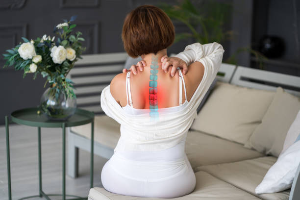 Intervertebral spine hernia, pain between the shoulder blades, woman suffering from backache at home, spinal disc disease stock photo