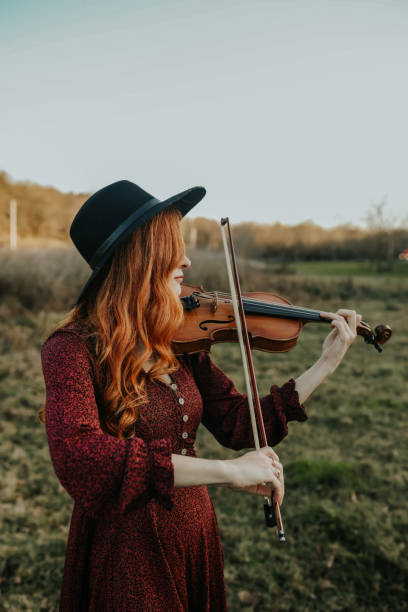 musicista donna ritratto, violino , autunno - classical music red violin bow foto e immagini stock