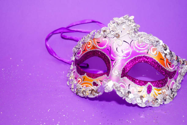 istock Purple-yellow carnival mask on a purple background. 1358594774