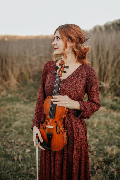 musicista donna ritratto, violino , autunno - classical music red violin bow foto e immagini stock