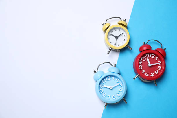 istock Modern alarm clocks on color background, flat lay. Space for text 1358603015