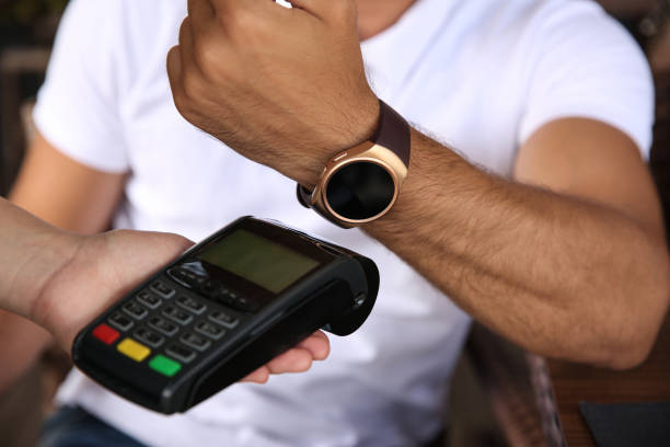 istock Man making payment with smart watch outdoors, closeup 1358603692