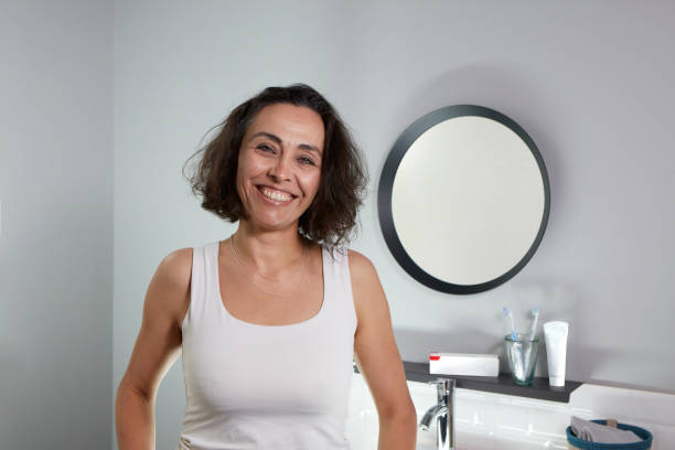 istock Mid-aged woman smiling in bathroom 1358606529