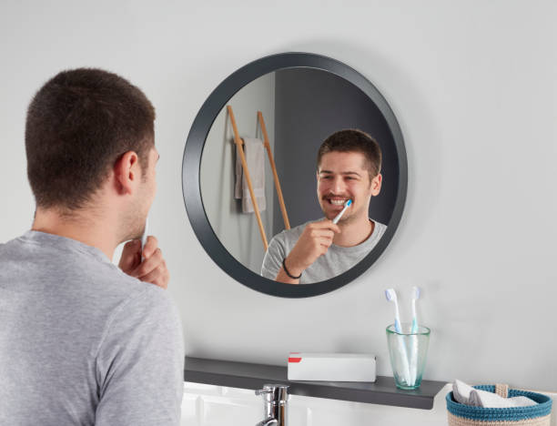 istock Reflection of a young man brushing his teeth 1358606871