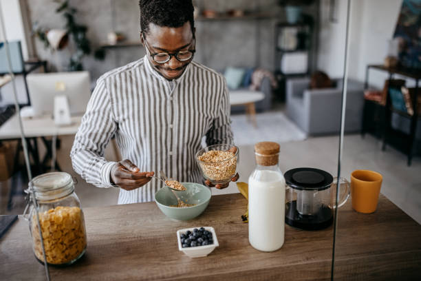 istock Men preparing breakfast in kitchen at home 1358609347