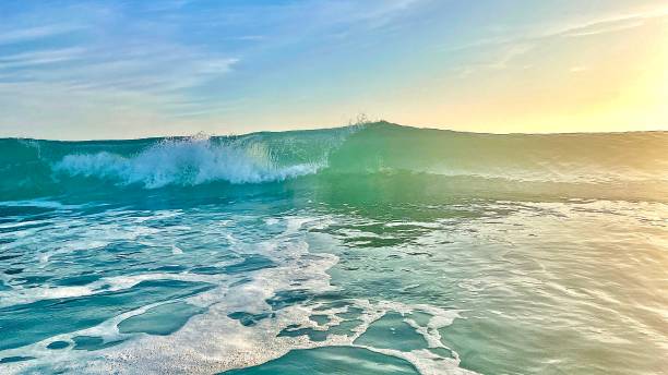 istock The turquoise wave breaking in a tropical sea - multi colored sky 1358610288