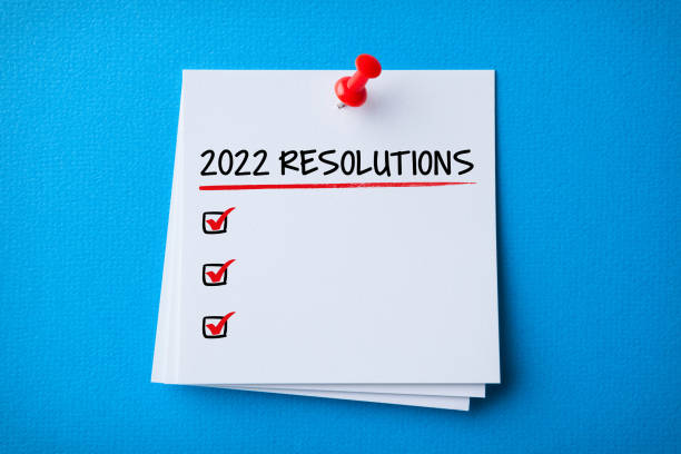 istock White Sticky Note With New Year 2022 Resolutions And Red Push Pin On Blue Background 1358610363