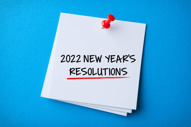 istock White Sticky Note With New Year 2022 Resolutions And Red Push Pin On Blue Background 1358610367