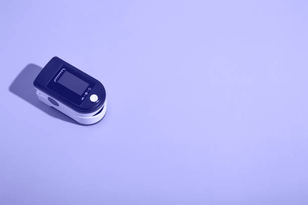 istock Portable pulse oximeter on a blue background with a hard shadow. Control of oxygen in the lungs. view from above 1358611327