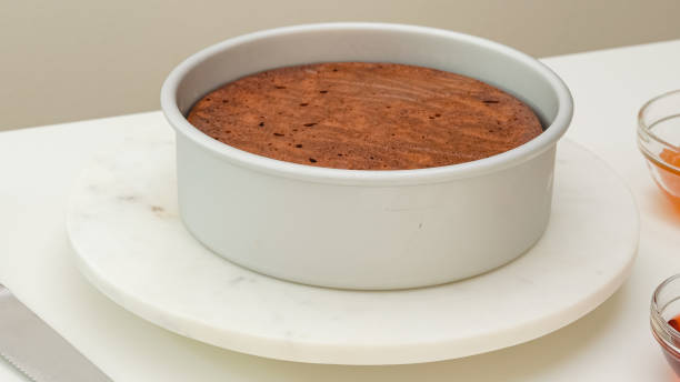 pastel de chocolate recién horneado en bandeja para hornear, justo desde el horno, vista de cerca en la mesa blanca kicthen - chocolate pot de creme fotografías e imágenes de stock