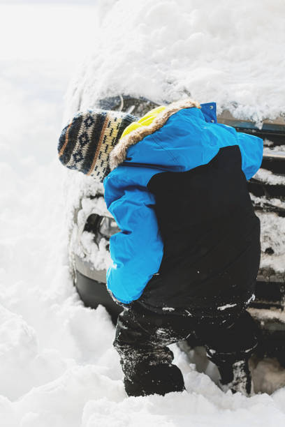 istock Boy Clears Snow From Car 1358612683