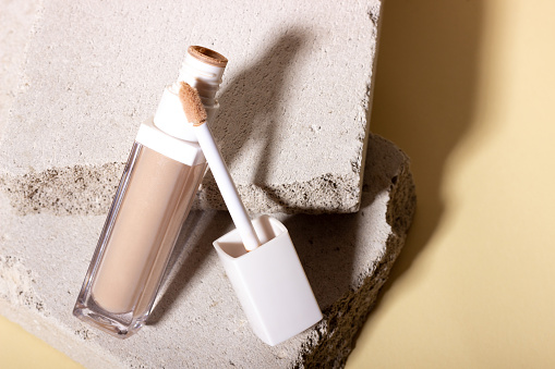 Foundation, concealer on a background of concrete geometric shapes.