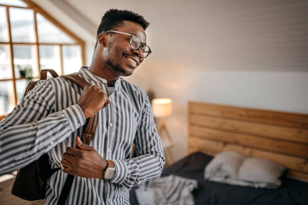 istock Happy man wearing backpack at home leaving for work 1358615209