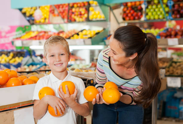 istock child with his mother choosing  oranges 1358619291