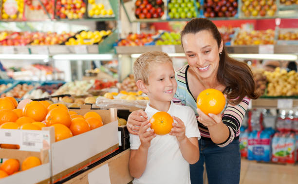istock child with female choosing  oranges 1358619297