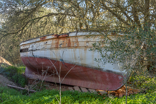 Abandoned sailboat in a field with Mediterranean wilderness, a sunny morning. Island of Mallorca, Spain