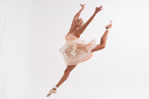 Ballerina is jumping on a white background.
