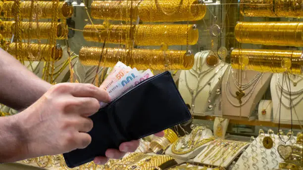 male hand taking money out of wallet in jewelery shop