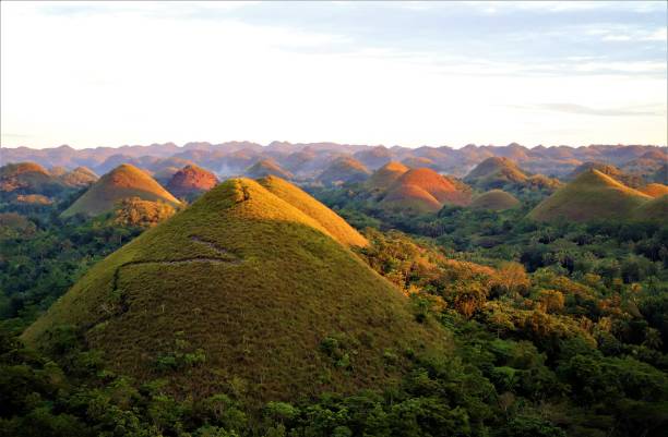 Chocolate Hills, Bohol, Philippines Chocolate Hills before sunset, neighbors are burning the fallen leaves in Bohol, Philippines. chocolate hills photos stock pictures, royalty-free photos & images