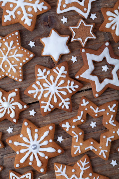 istock Gingerbread Christmas gingerbread cookies star shape with white icing full frame on brown wooden table. 1358625703