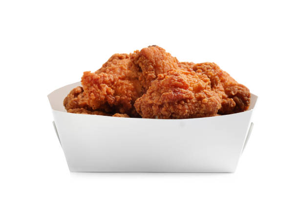 istock Tasty deep fried chicken pieces isolated on white 1358630594