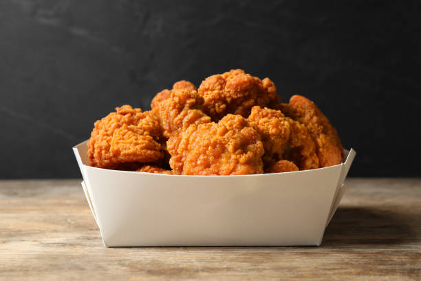 istock Tasty deep fried chicken pieces on wooden table 1358630934