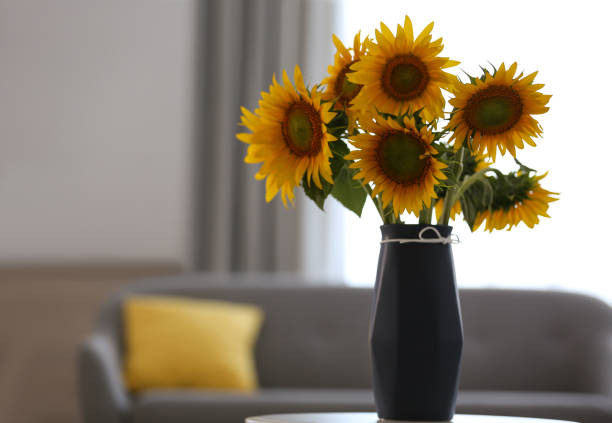 istock Vase with beautiful yellow sunflowers on table in room, space for text 1358631094