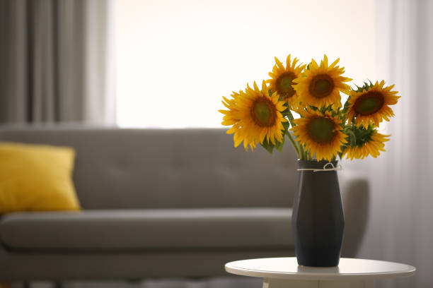 istock Vase with beautiful yellow sunflowers on table in room, space for text 1358631315