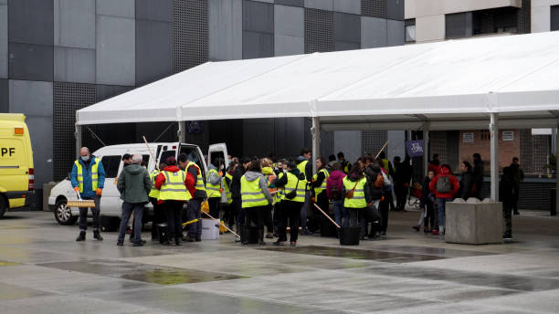 persone in giubbotti riflettenti nella piazza della città - emergency management foto e immagini stock