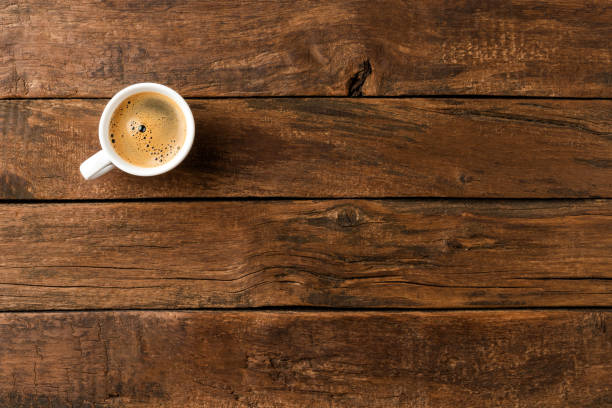 istock Coffee cup on vintage wooden table with copyspace. Top view 1358633304
