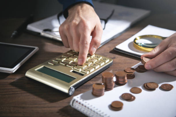 istock Businessman counting coins on the desk. 1358633938