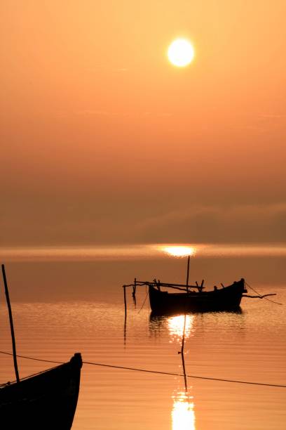 istock fishing boat at sunrise 1358636548
