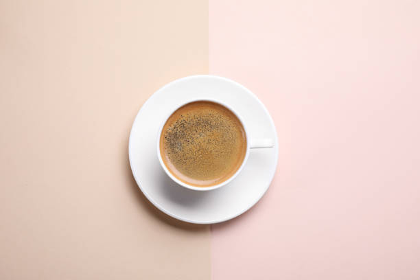 istock Cup of aromatic coffee on color background, top view 1358637328