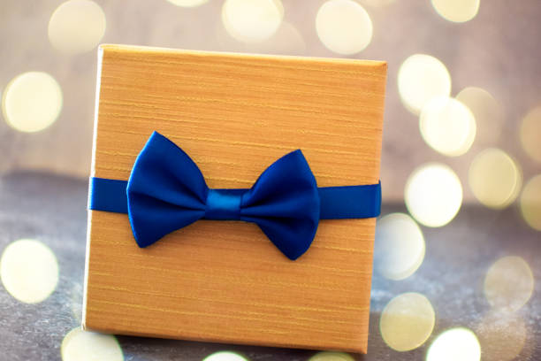 Beautifully wrapped birthday present in blue paper with gold ribbon