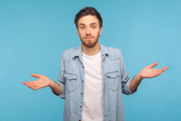 istock Man shrugging shoulders, uncertain, has no answer, looking at camera with confused face. 1358639058