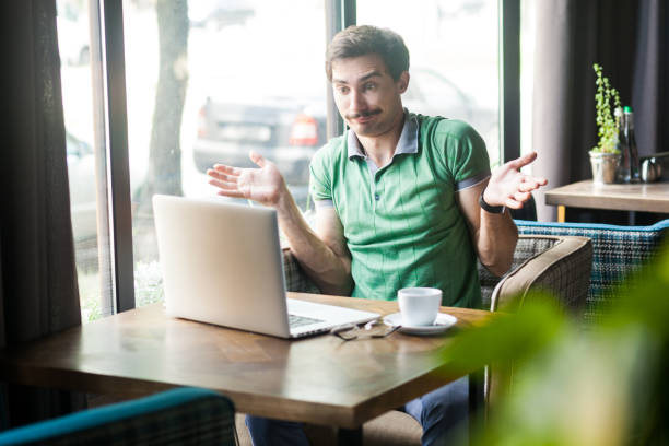 istock Man working online on laptop, shrugging shoulders, making no idea gesture, whatever. 1358639059