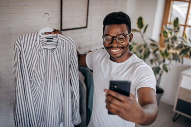 istock Man recording blog while showing clothes as influencer 1358639120