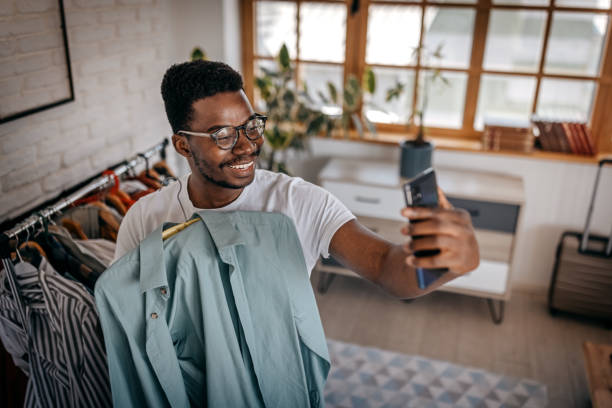 istock Man recording blog while showing clothes as influencer 1358639219