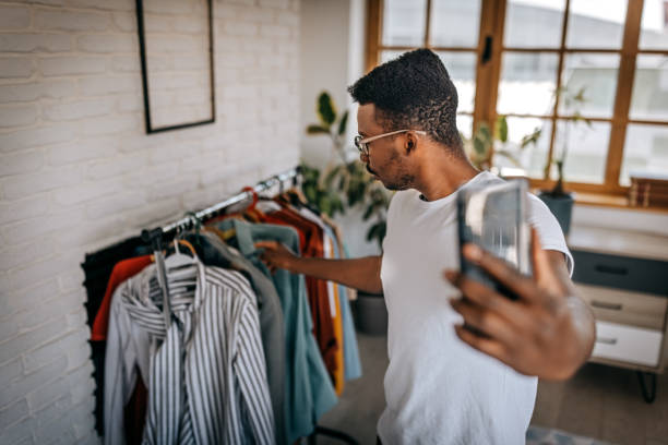 istock Man recording blog while showing clothes as influencer 1358639250