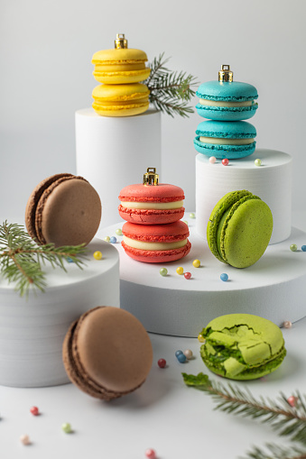 Christmas multicolored macarons on white pedestals background