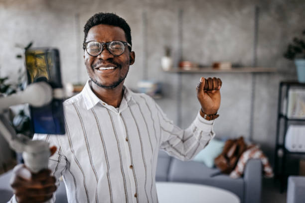 istock Cheerful young man excited recording vlog at home 1358640206