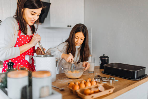 istock Mom and daughter baking cakes in her kitchen 1358641441