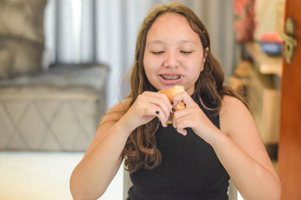 istock Young girl at home, eating bread 1358644376