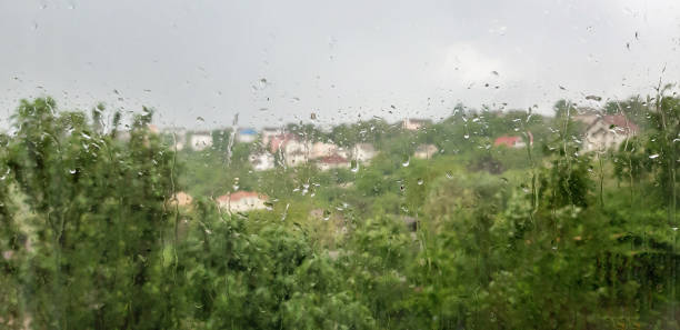 istock Summer rain concept - raindrops on the window - in the background beautiful nature 1358646461