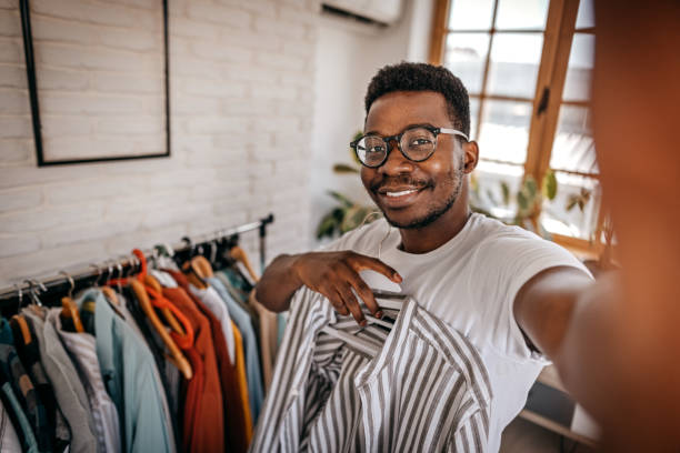 hombre tomando selfie mientras elige ropa - clothing store fotos fotografías e imágenes de stock